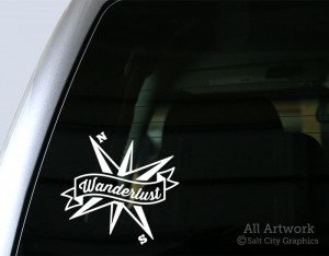 Wanderlust Banner with Compass Decal in White shown on truck window